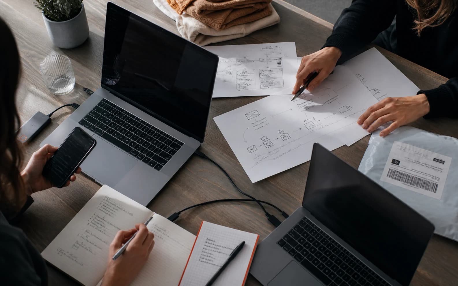 A team mapping customer communication and business workflows across one shared worktable